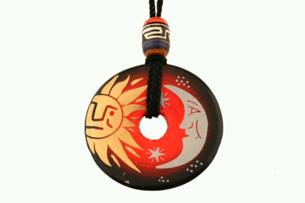 Wisiorek z motywem słońca i księżyca na czarnym sznurku z kolorową koralikową ozdobą.