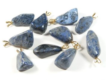 Niebieskie kamienie z oczkami do zawieszenia, ułożone na białym tle.