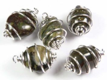 Lakelandyt szlifowany w spirali - wisiorek na sznureczku. Pięć kamieni owiniętych spiralnie srebrnym drutem na białym tle.