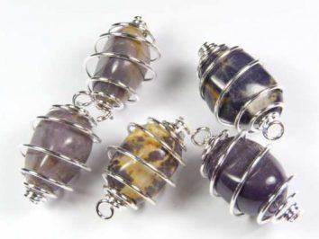 Waryscyt fioletowy gładzony w spirali - wisiorek na sznureczku. Cztery kamienie ozdobne w srebrnych spiralnych koszyczkach na białym tle.