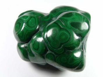 Gładki, zielony minerał malachit o charakterystycznych jasnych wzorach na powierzchni.