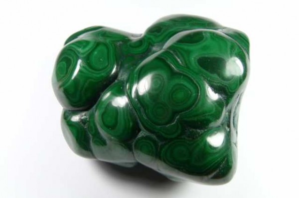 Gładki, zielony minerał malachit o charakterystycznych jasnych wzorach na powierzchni.