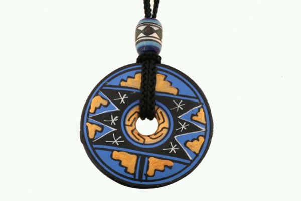 Okrągły wisiorek z niebiesko-żółtym wzorem etnicznym zawieszony na czarnym sznurku.