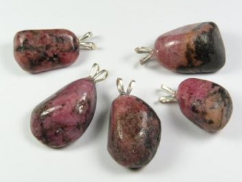 Pięć różowo-czarnych kamieni z zawieszkami, ułożonych na białym tle.