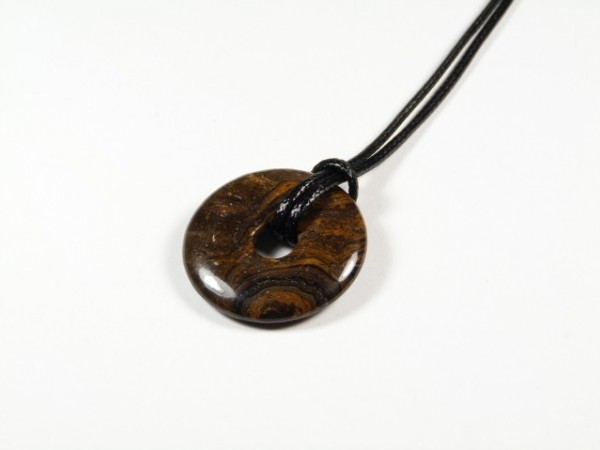 Brązowy, kamienny wisiorek w kształcie krążka na czarnym sznurku, na białym tle.