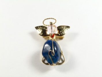 Broszka aniołek z niebieskim kamieniem, złotymi skrzydłami i aureolą na białym tle.