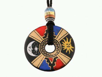 Wisiorek okrągły z symbolem słońca, księżyca i kolorowymi wzorami na czarnym tle.