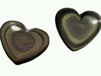 Dwa serca z kamienia obsydianu tęczowego na jasnym tle.