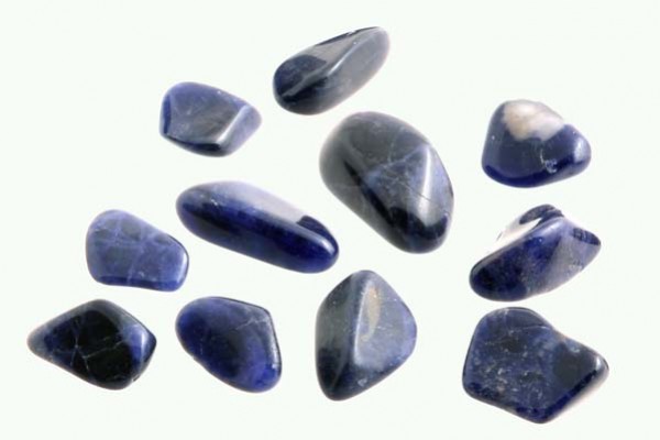 Jedenaście wypolerowanych, granatowych kamieni leży na jasnym tle.