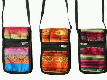 Trzy kolorowe, etniczne torebki na pasku z zamkami błyskawicznymi, ustawione obok siebie.