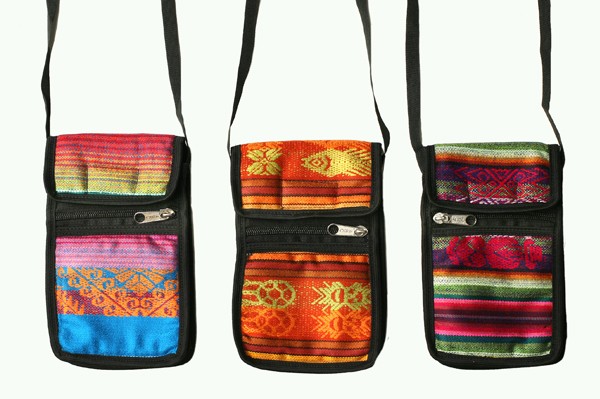 Trzy kolorowe, etniczne torebki na pasku z zamkami błyskawicznymi, ustawione obok siebie.