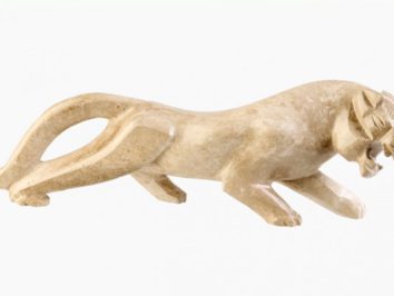 Kamiczna rzeźba przedstawiająca geparda w pozycji do ataku, na białym tle.