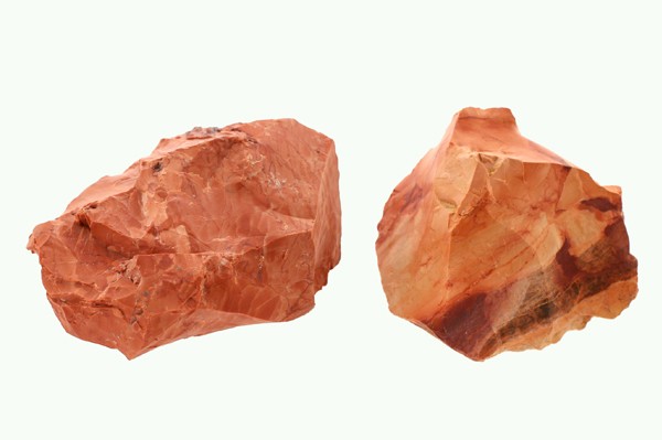 Dwa kawałki czerwonego jaspisu na jasnym tle.
