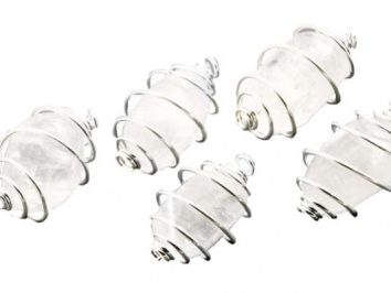 Cztery kamienie owinięte srebrnym drutem leżą na białym tle.