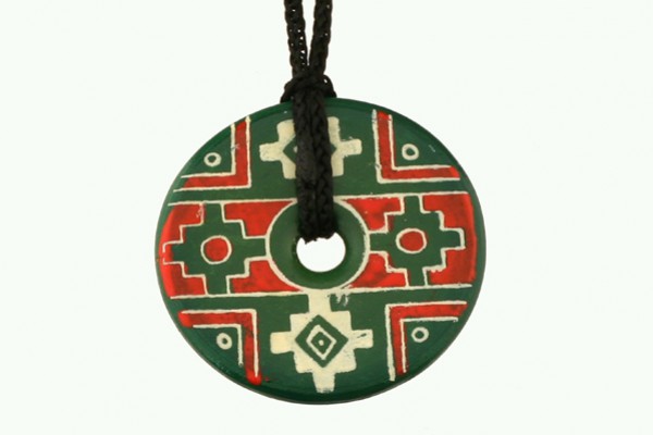 Okrągły, zielony wisiorek z ludowym wzorem w czerwono-białe geometryczne kształty na czarnym sznurku.