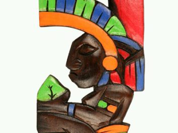 Drewniana, kolorowa rzeźba przedstawiająca profil wojownika azteckiego w hełmie z pióropuszem.