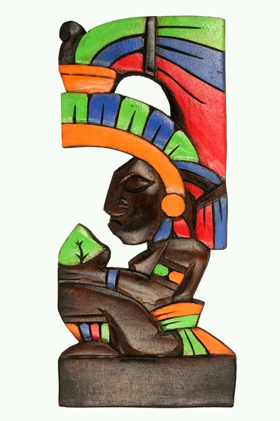 Drewniana, kolorowa rzeźba przedstawiająca profil wojownika azteckiego w hełmie z pióropuszem.