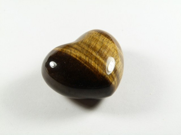 Polerowany kamień tygrysie oko w kształcie serca na białym tle.