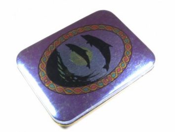 Fioletowa metalowa puszka z obrazkiem dwóch delfinów na wieczku.