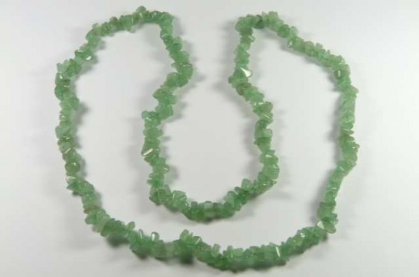 Zielony naszyjnik z drobnych, nieregularnych kamieni ułożony na białym tle.