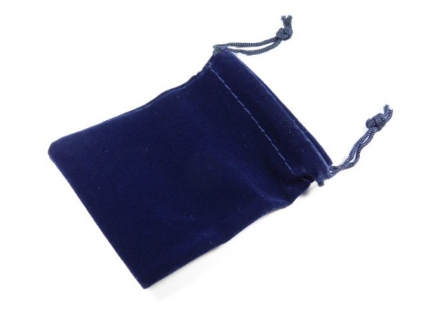 Granatowy, welurowy woreczek ze ściągaczem leży na białym tle.