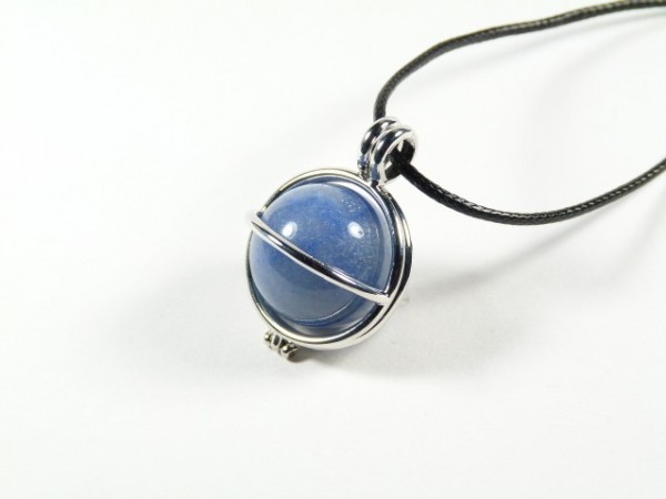 Srebrny naszyjnik z zawieszką w kształcie niebieskiej kuli na czarnym sznurku.