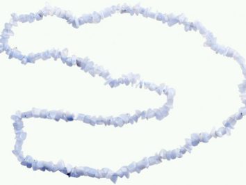 Naszyjnik z drobnych, białych kamieni ułożony w kształt otwartej pętli na jasnym tle.