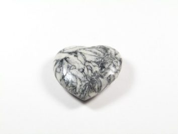 Serce z białego marmuru z szarymi żyłkami, leżące na białym tle.