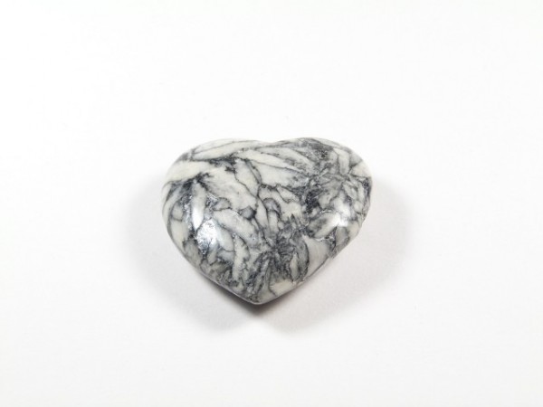 Serce z białego marmuru z szarymi żyłkami, leżące na białym tle.