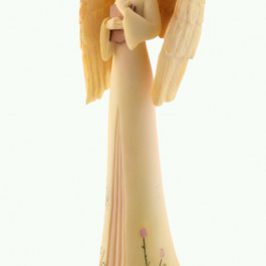 Figurka anioła z długimi skrzydłami i jasną suknią, trzymającego ręce przy sercu.