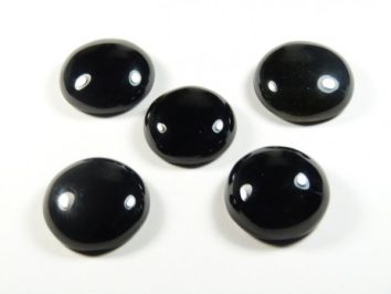 Pięć czarnych, okrągłych kamieni na białym tle.