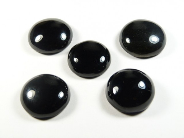 Pięć czarnych, okrągłych kamieni na białym tle.