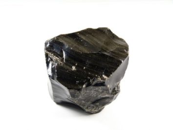 Czarny kawałek obsydianu na białym tle.