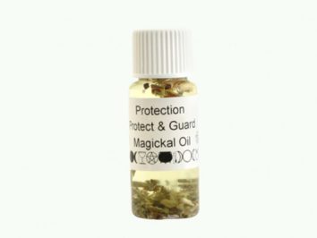 Mała butelka olejku ochronnego z ziołami, etykieta z napisem „Protection Magickal Oil”.