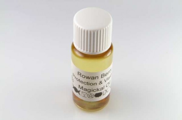 Mała butelka z żółtym olejkiem, z etykietą „Rowan Berry Magickal Oil”.