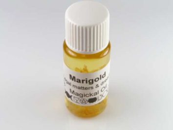Mała buteleczka z żółtym olejkiem nagietkowym, etykieta z napisem "Marigold Magickal Oil".