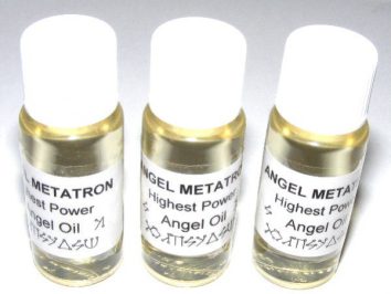 Trzy buteleczki olejku anielskiego "Angel Metatron" ustawione obok siebie na białym tle.