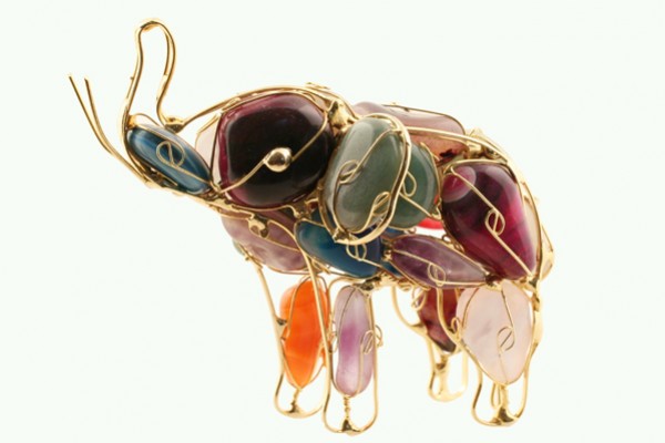 Figurka słonia wykonana z kolorowych kamieni i drutu na jasnym tle.