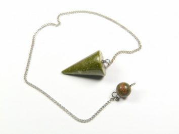 Wahadełko unakit stożek. Zielone wahadełko na srebrnym łańcuszku leży na białym tle.