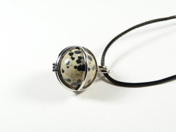 Naszyjnik z kulką z czarno-białego kamienia, oprawioną w srebrny drucik, na czarnym sznurku.