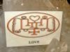 Kartka z napisem „LOVE” i symbolicznym rysunkiem z sercem pośrodku.