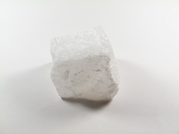 Biały, półprzezroczysty kryształ soli na białym tle.