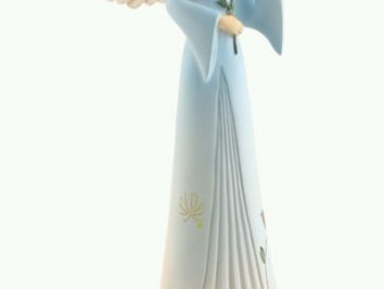 Figurka anioła w niebieskiej sukni trzymającego gołębia na dłoni.