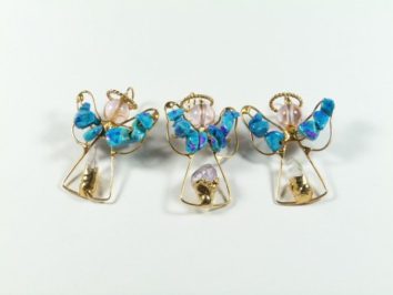 Trzy aniołki z drutu i kolorowych koralików ustawione obok siebie na białym tle.