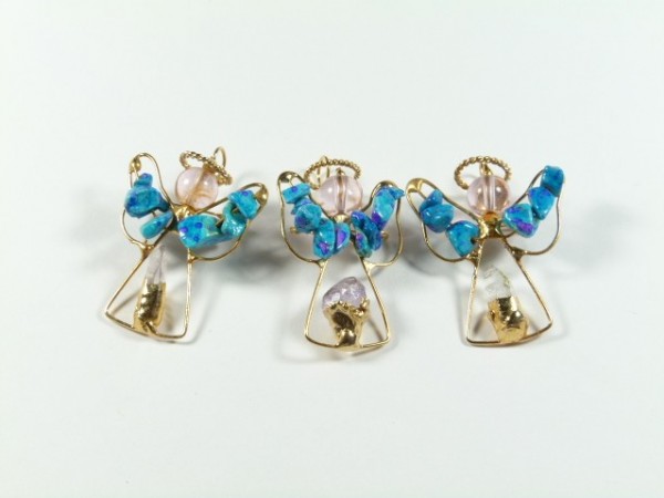 Trzy aniołki z drutu i kolorowych koralików ustawione obok siebie na białym tle.