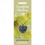 Naszyjnik z kamieniem obsydian śnieżny w kształcie serca na tle żółtych kwiatów.