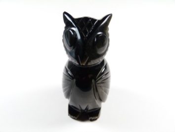 Czarna figurka sowy z kamienia, ustawiona na białym tle.