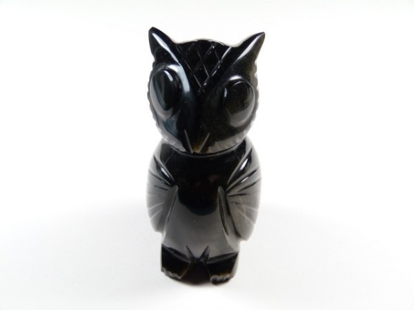 Czarna figurka sowy z kamienia, ustawiona na białym tle.