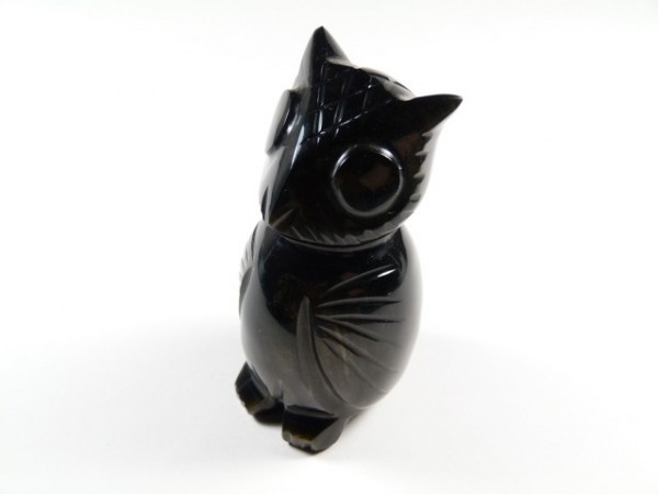 Czarna figurka sowy wykonana z kamienia, ustawiona na białym tle.