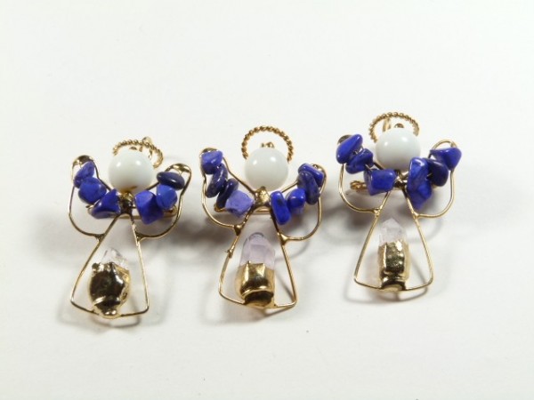 Trzy ręcznie wykonane aniołki z drutu i koralików, ustawione obok siebie na białym tle.